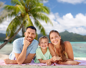 Image showing happy family lying over tropical beach background