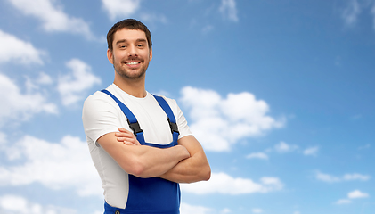 Image showing happy smiling male worker or builder in overall