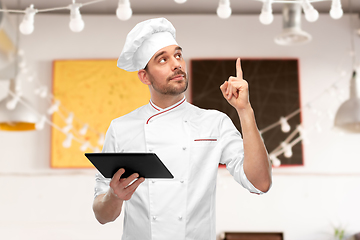 Image showing male chef with tablet computer pointing finger up