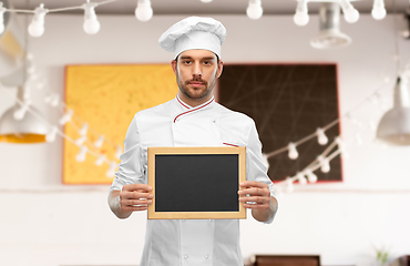 Image showing male chef showing empty chalkboard at restaurant