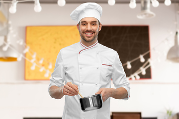 Image showing happy smiling male chef with saucepan cooking food