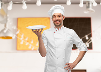 Image showing happy smiling male chef holding empty plate