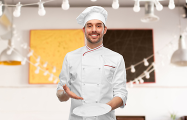 Image showing happy smiling male chef holding empty plate