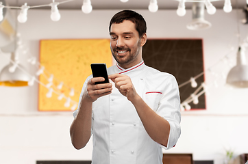 Image showing happy smiling male chef with smartphone