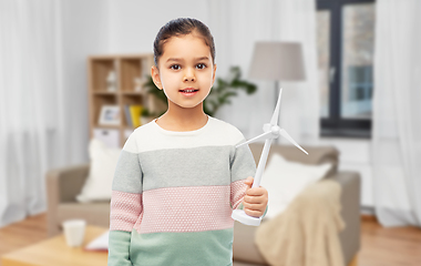 Image showing smiling girl with toy wind turbine at home