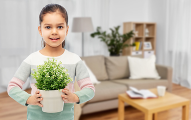 Image showing happy smiling girl holding flower in pot at home