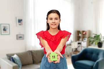 Image showing smiling girl holding green house icon at home