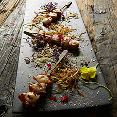 Image showing Snack from pieces of an octopus on a wooden skewer. Film effect