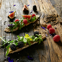 Image showing Three portions of homemade dessert fresh berries on a wooden background