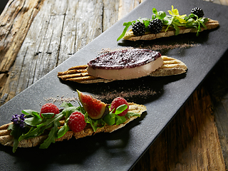 Image showing Three portions of homemade dessert fresh berries on a wooden background