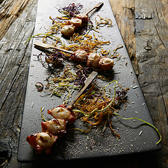 Image showing Snack from pieces of an octopus on a wooden skewer. Film effect