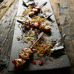 Image showing Snack from pieces of an octopus on a wooden skewer. Film effect