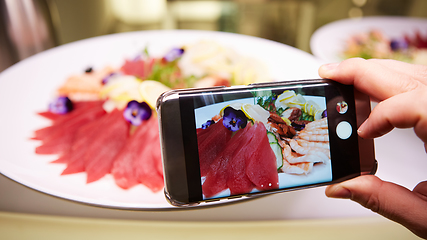 Image showing Hands taking picture of sashimi japan food with smartphone.