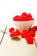 Image showing bunch of fresh raspberry on a bowl and white table