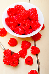 Image showing bunch of fresh raspberry on a bowl and white table