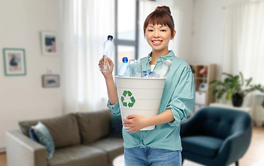 Image showing smiling young asian woman sorting plastic waste