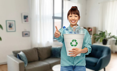 Image showing smiling young asian woman sorting plastic waste