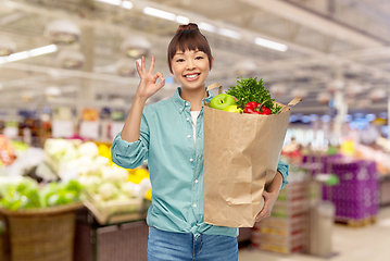 Image showing happy asian woman with food in paper shopping bag