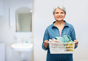 Image showing smiling senior woman with laundry basket