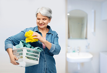 Image showing smiling senior woman with laundry basket