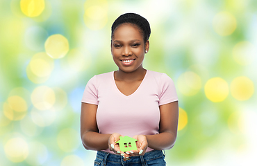 Image showing smiling african american woman holding green house