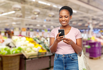 Image showing woman with smartphone and food in string bag