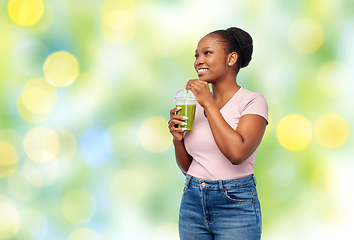 Image showing happy african american woman drinking green juice