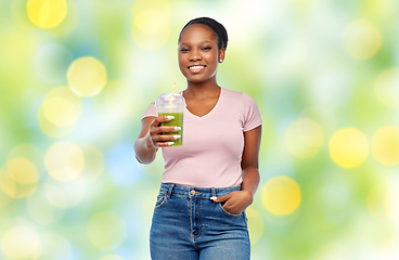 Image showing happy african american woman drinking green juice