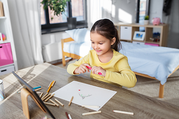 Image showing little girl drawing with coloring pencils at home