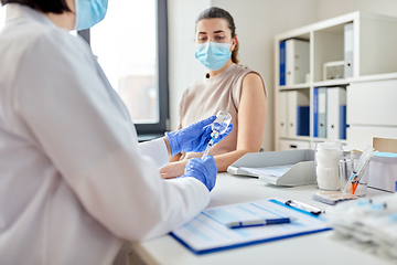 Image showing female doctor with syringe vaccinating patient