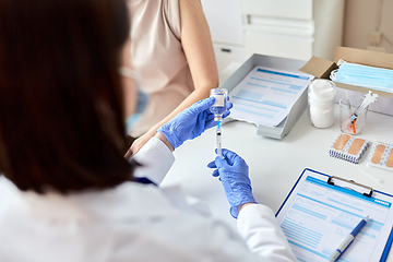 Image showing female doctor with syringe vaccinating patient