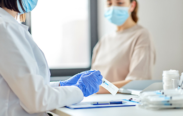 Image showing female doctor with syringe and patient at hospital