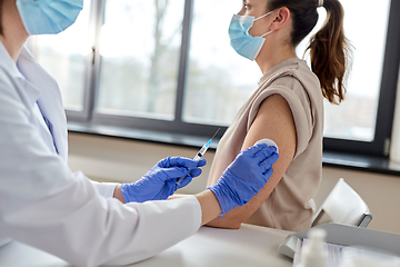 Image showing female doctor with syringe vaccinating patient