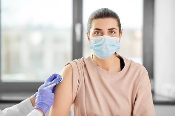 Image showing female doctor with syringe vaccinating patient