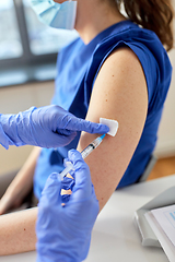 Image showing doctor with syringe vaccinating medical worker