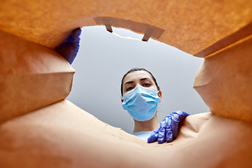 Image showing woman in gloves and mask with food in paper bag