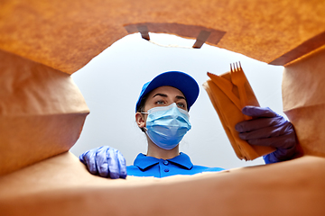 Image showing delivery girl in gloves and mask with food in bag