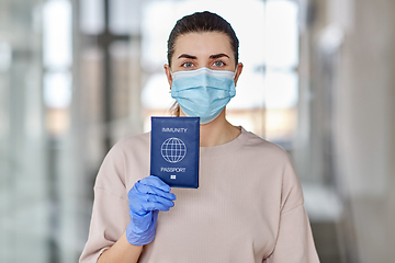Image showing woman in mask and gloves holding immunity passport