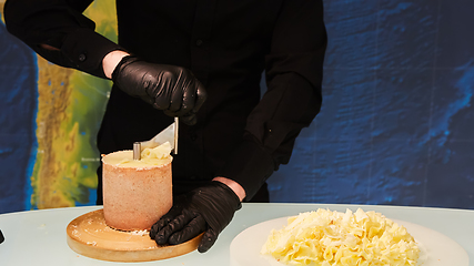 Image showing Special cheese knives. The girolle scraper. Making cheese shaving on girolle, closeup