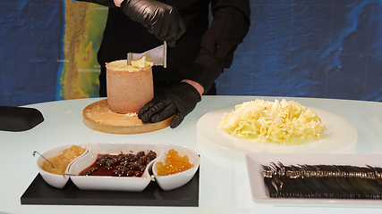 Image showing Special cheese knives. The girolle scraper. Making cheese shaving on girolle, closeup