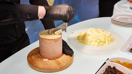 Image showing Special cheese knives. The girolle scraper. Making cheese shaving on girolle, closeup