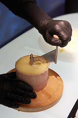 Image showing Special cheese knives. The girolle scraper. Making cheese shaving on girolle, closeup