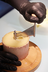 Image showing Special cheese knives. The girolle scraper. Making cheese shaving on girolle, closeup