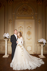 Image showing Charming wedding couple in interior in Baroque style is hugging each other on great royal palace