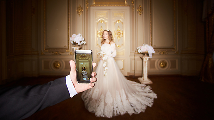 Image showing Photographing a bride by the smartphone in luxury interior in the Baroque style.