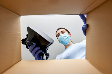 Image showing woman in mask taking vr glasses out of parcel box