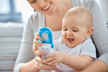 Image showing mother with baby playing with toy phone at home