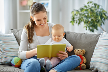Image showing happy mother reading book to little baby at home