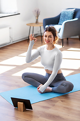 Image showing young woman with tablet pc doing yoga at home