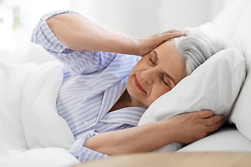 Image showing annoyed senior woman with headache in bed at home